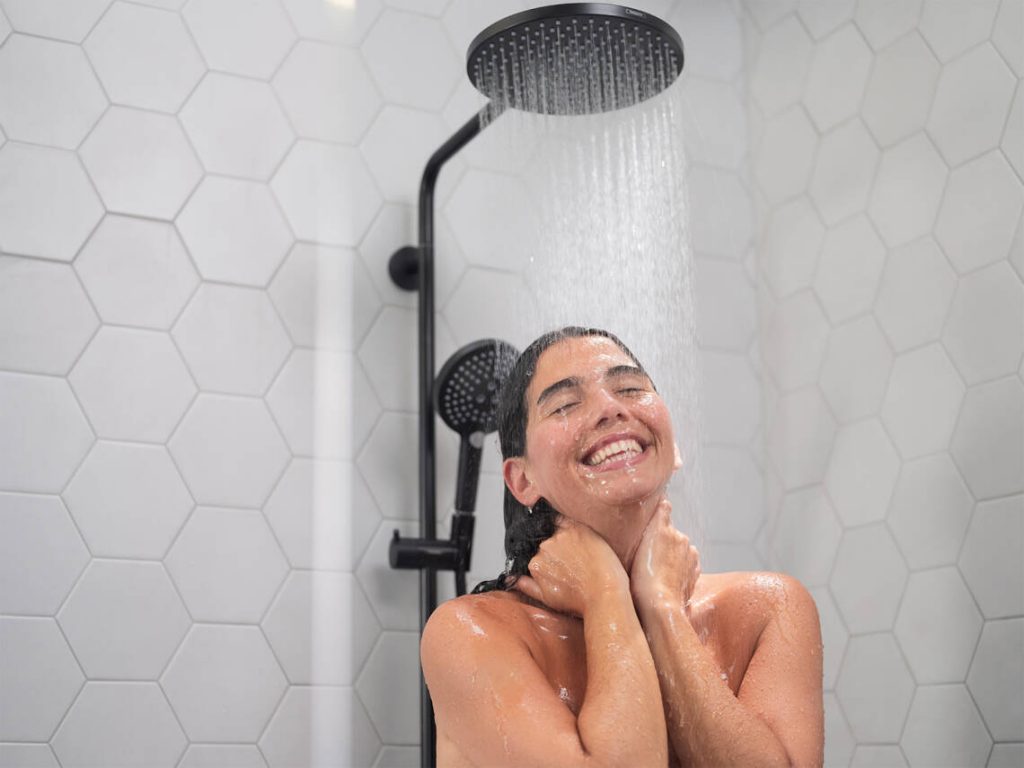 raindance-showerpipe_mattblack-powderrain_happy-woman_4x3